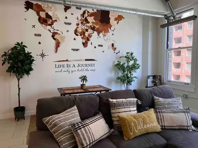 a living room with a couch with a world map on the wall at Iconic Heart of DTLA Loft with Rooftop Pool Jacuzzi Gym in Los Angeles