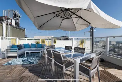 a patio with a table and chairs and an umbrella at Iconic Heart of DTLA Loft with Rooftop Pool Jacuzzi Gym in Los Angeles