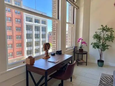 an office with a desk and two large windows at Iconic Heart of DTLA Loft with Rooftop Pool Jacuzzi Gym in Los Angeles