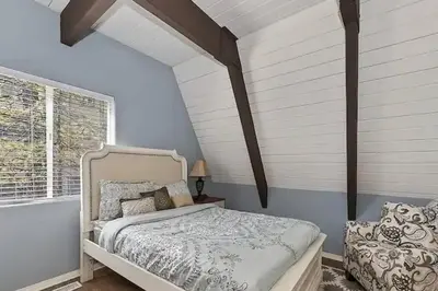 a bedroom with a white bed and a window at Whispering Pines A-Frame, Pool Table, 2 Patios! in Lake Arrowhead