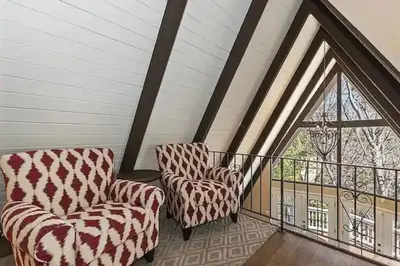 two chairs sitting on a balcony with a window at Whispering Pines A-Frame, Pool Table, 2 Patios! in Lake Arrowhead