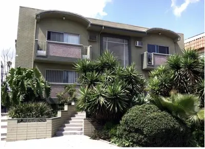 a house with palm trees in front of it at Cozy spot in Koreatown in Los Angeles