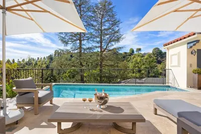a patio with a table and an umbrella and a pool at Chateau Beverly Hills by Stay Awhile Villas in Los Angeles