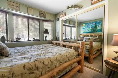 a bedroom with a large bed and a large mirror at Smo Haus- Located in the quiet area of Big Bear City, with mountain views. in Big Bear City