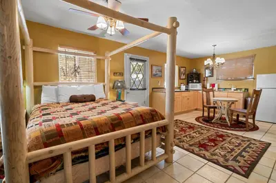 a bedroom with a wooden bed and a kitchen at Smo Haus- Located in the quiet area of Big Bear City, with mountain views. in Big Bear City