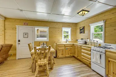 a kitchen with wooden walls and a table and chairs at Walk to Water Cozy Cabin in Green Valley Lake! in Green Valley Lake