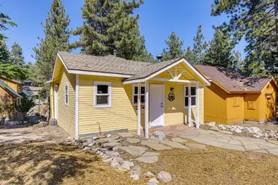 a yellow tiny house in a yard at Walk to Water Cozy Cabin in Green Valley Lake! in Green Valley Lake
