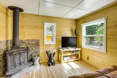 a living room with a fireplace and a tv at Walk to Water Cozy Cabin in Green Valley Lake! in Green Valley Lake