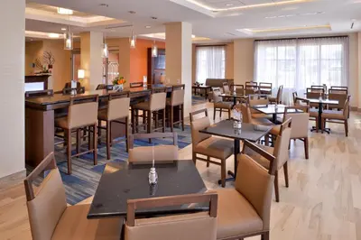 a restaurant with tables and chairs in a room at Holiday Inn Express Hotels & Suites Loma Linda by IHG in Loma Linda