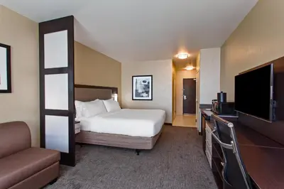 a hotel room with a bed and a flat screen tv at Holiday Inn Express & Suites Anaheim Resort Area by IHG in Anaheim
