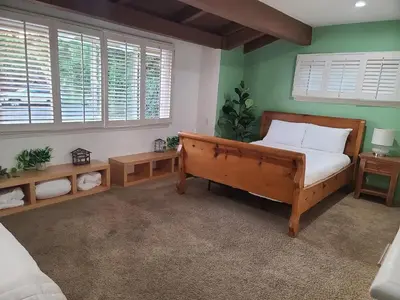 a bedroom with a bed and two tables and a window at Westside Retreat w Yard, Grill, Hot Tub, Near Sofi Stadium, LAX, and the Beach in Los Angeles
