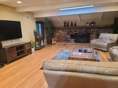 a living room with couches and a flat screen tv at Westside Retreat w Yard, Grill, Hot Tub, Near Sofi Stadium, LAX, and the Beach in Los Angeles