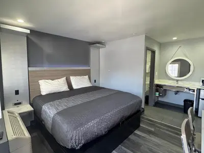a bedroom with a bed and a sink in it at Bronco Motel South Central in Los Angeles