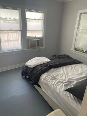 a bed in a bedroom with two windows at Hancock weho in Los Angeles