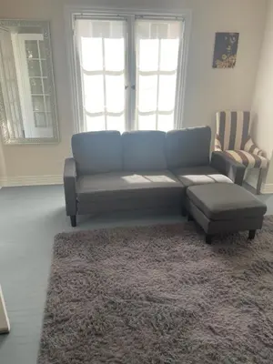 a living room with a blue couch and a rug at Hancock weho in Los Angeles