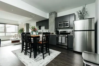 a kitchen with a table and chairs and a refrigerator at Hollywood Designer Apartment in Los Angeles