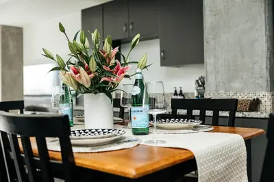 a dining room table with a vase of flowers on it at Hollywood Designer Apartment in Los Angeles