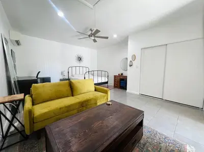 a living room with a yellow couch and a table at Great Private Studio in Noho in Los Angeles