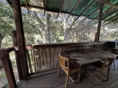 a wooden table and chairs on a wooden deck at Japanese Tea House with Private Mountain Trails and Creek in Topanga Park