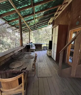 a porch of a cabin with a table and chairs at Japanese Tea House with Private Mountain Trails and Creek in Topanga Park