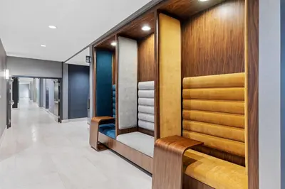 a dressing room with wood paneling and a shelf with towels at La Quinta Inn & Suites by Wyndham La Habra in La Habra
