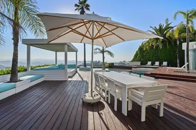 a white table and chairs with an umbrella on a deck at Crest Estate by Stay Awhile Villas in Los Angeles