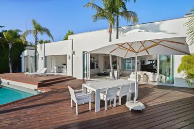 a white table with chairs and an umbrella on a deck at Crest Estate by Stay Awhile Villas in Los Angeles