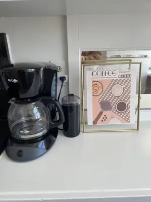 a coffee maker sitting on a counter next to a picture at Chambre de Bonne in Downtown Long Beach in Long Beach