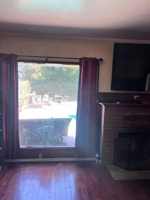 a living room with a large window and a fireplace at Cozy Room In Downey in Downey