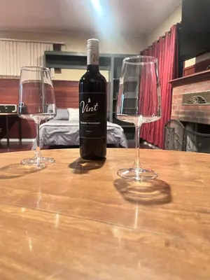a bottle of wine sitting on a table with two glasses at Cozy Room In Downey in Downey