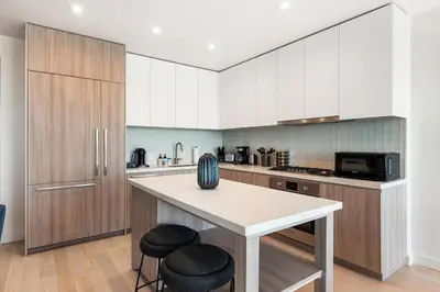 a kitchen with a counter and two stools at The Rose Quartz - Rooftop Pool, Gym Glamorous Santa Monica 2BR in Los Angeles