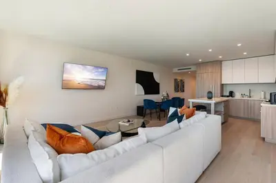 a living room with a white couch and a kitchen at The Rose Quartz - Rooftop Pool, Gym Glamorous Santa Monica 2BR in Los Angeles