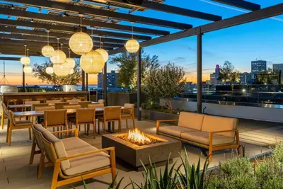 a patio with tables and chairs and a fire pit at The Rose Quartz - Rooftop Pool, Gym Glamorous Santa Monica 2BR in Los Angeles