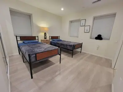 a bedroom with two beds and a cat sitting in the window at Prime LA 2 bedroom & 3 bath home Beverly Hills adj in Los Angeles