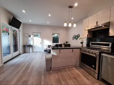 a large kitchen with wooden floors and stainless steel appliances at Prime LA 2 bedroom & 3 bath home Beverly Hills adj in Los Angeles