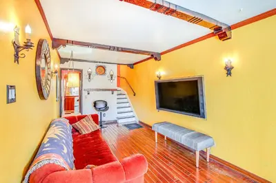 a living room with a couch and a flat screen tv at 1 Mi to Ocean! Home with Rooftop Deck in Long Beach in Long Beach