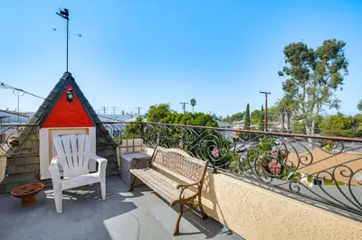 a balcony with a bench and a small house at 1 Mi to Ocean! Home with Rooftop Deck in Long Beach in Long Beach