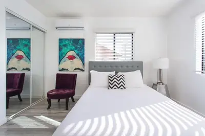 a white bedroom with a bed and two chairs at Sunny Studio in the Heart of Venice Beach - #5 in Los Angeles