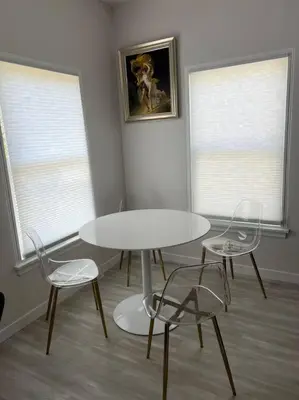 a table and two chairs in a room with two windows at Marilyn Studio Apartment in Koreatown in Los Angeles