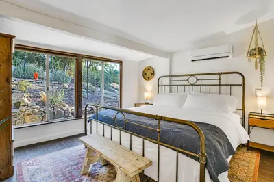 a bedroom with a bed and a bench and a window at Private Romantic Escape, Hidden Gem w Hot Tub in Chatsworth Lake Manor
