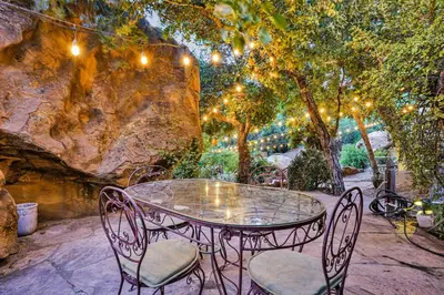 a metal table and chairs with lights on a patio at Private Romantic Escape, Hidden Gem w Hot Tub in Chatsworth Lake Manor
