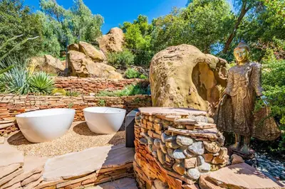 a statue of a woman next to a stone wall at Private Romantic Escape, Hidden Gem w Hot Tub in Chatsworth Lake Manor
