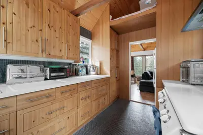 a kitchen with wooden cabinets and a stove at Mountain Cottage - Hot Tub! Walk to Lake and National Forest Hiking Trails in Big Bear Lake