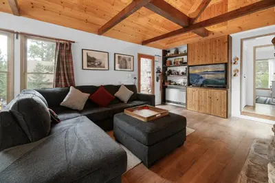 a living room with a couch and a tv at Mountain Cottage - Hot Tub! Walk to Lake and National Forest Hiking Trails in Big Bear Lake