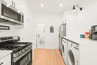 a kitchen with a stove and a washer and dryer at Cozy Retreat Near Downtown - Perfect for Families in Long Beach