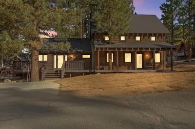 a large wooden house with a porch and trees at Dream Catcher Retreat in Big Bear Lake