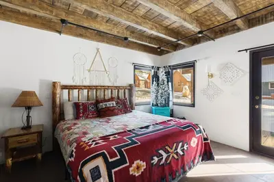 a bedroom with a bed with a red comforter at Dream Catcher Retreat in Big Bear Lake