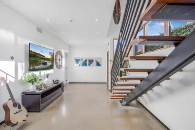 a living room with a staircase and a guitar at Cedar Loft Villa in Los Angeles