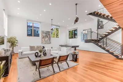 a living room with white furniture and a staircase at Cedar Loft Villa in Los Angeles