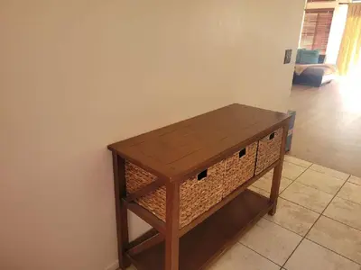 a wooden table with a wicker shelf in a room at 3BR & Loft near Palmdale Hospital in Palmdale